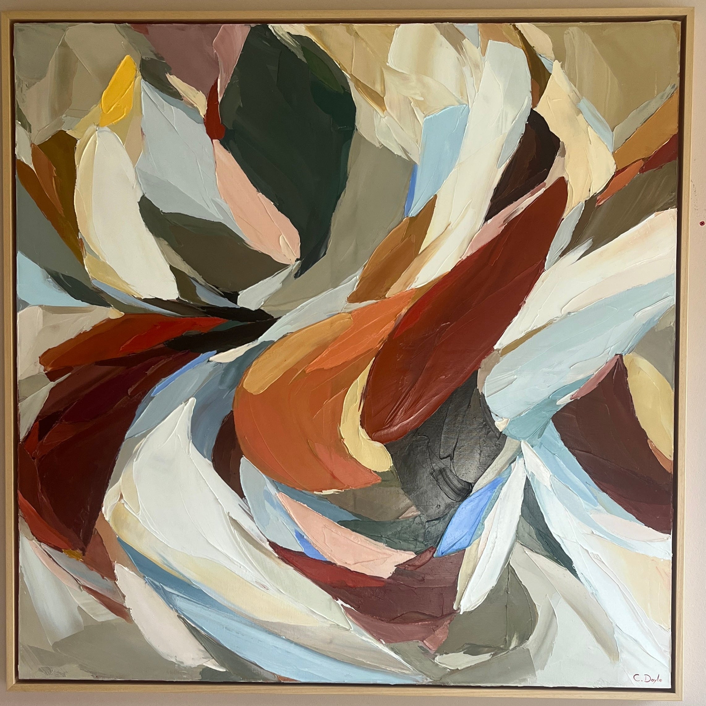 Abstract painting with swirling colors in a gold frame