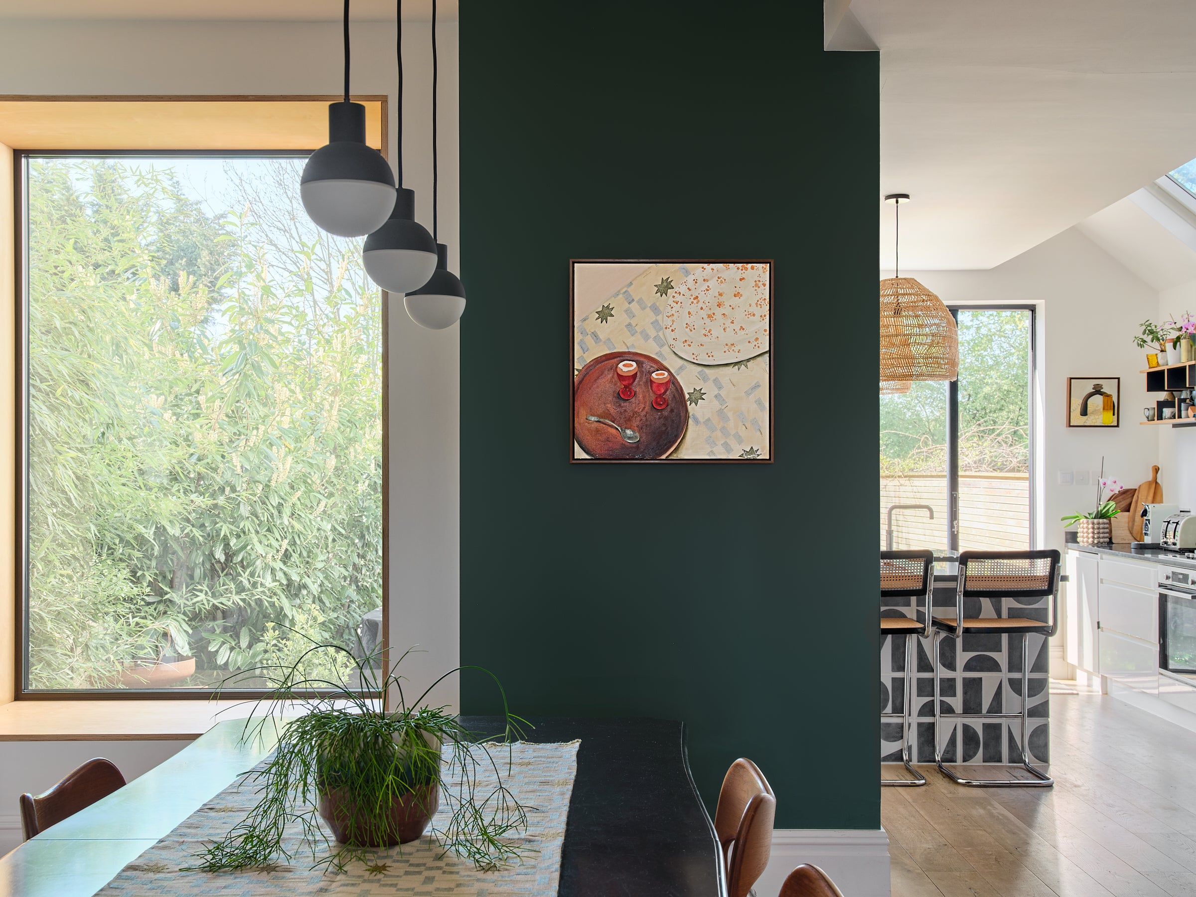 Painting of Boiled Eggs in an open plan living room , sat on a green wall.