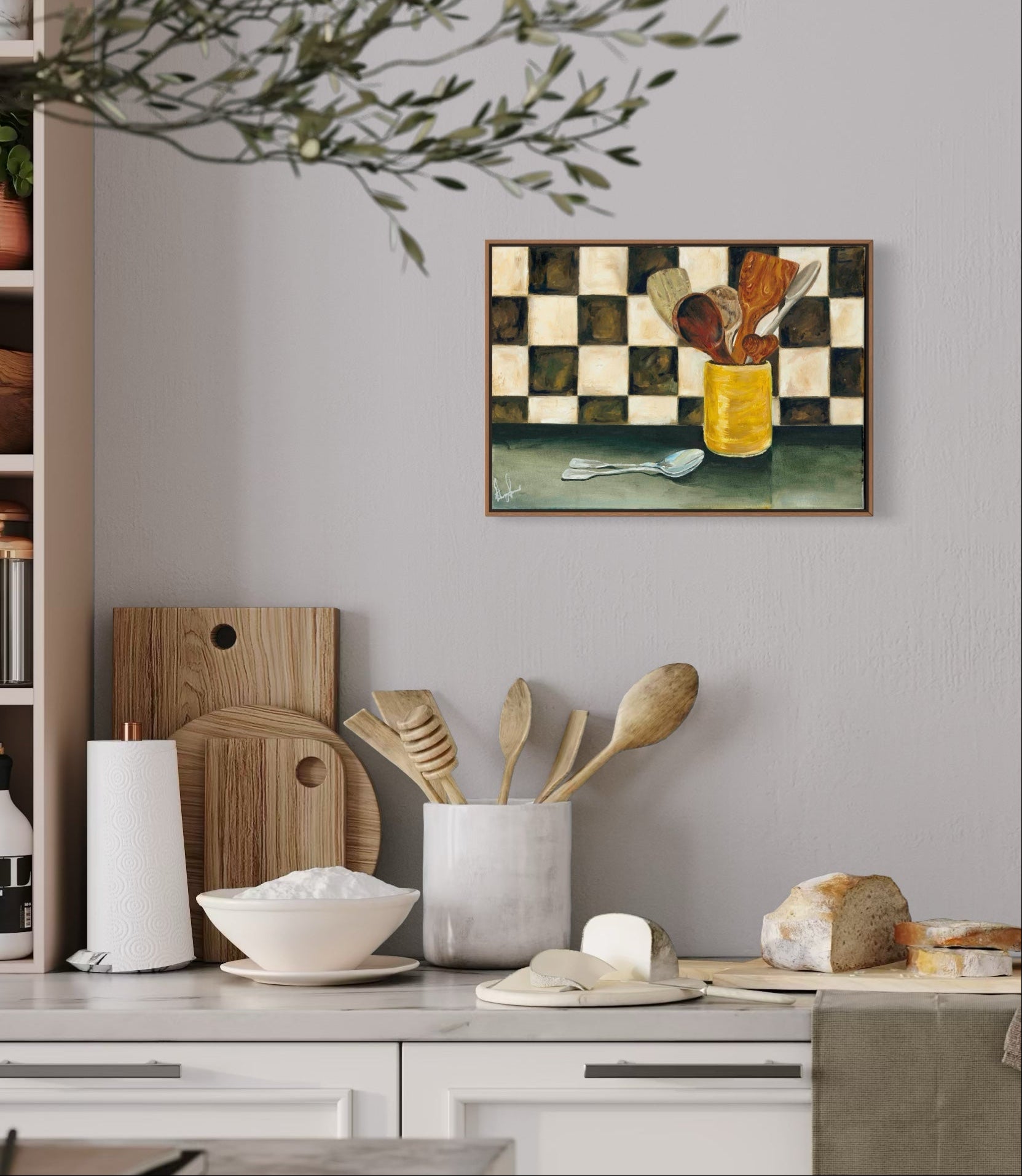 Kitchen counter with wooden utensils, a checkered painting, and shelves with kitchen items.