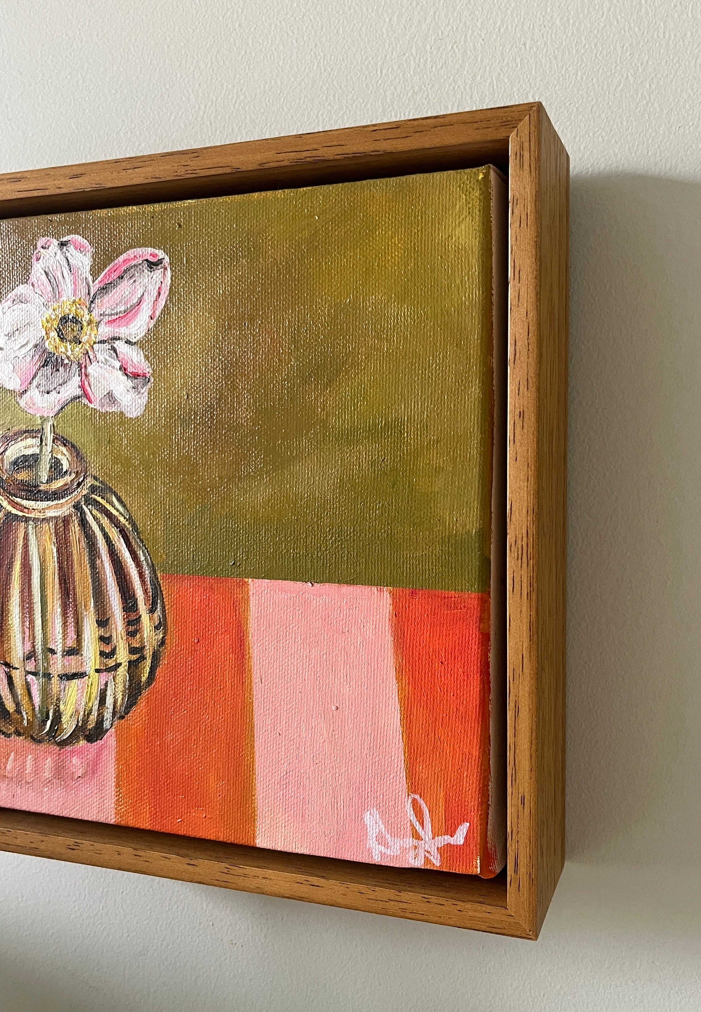 Small Emma Gurner painting with a floral design in a wooden frame on a white wall.