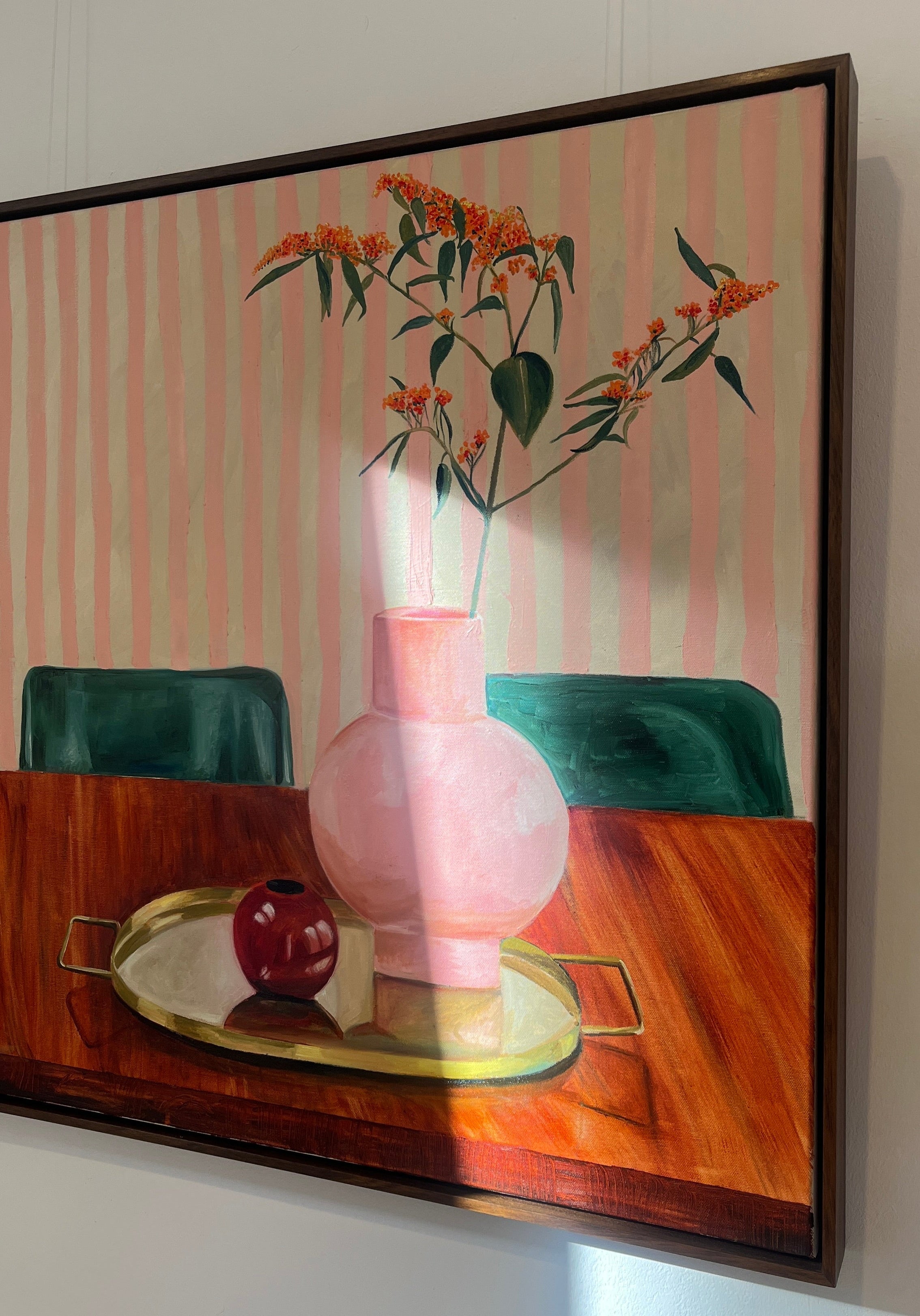 Framed artwork of a still life with a pink vase, green apples, and a striped background.