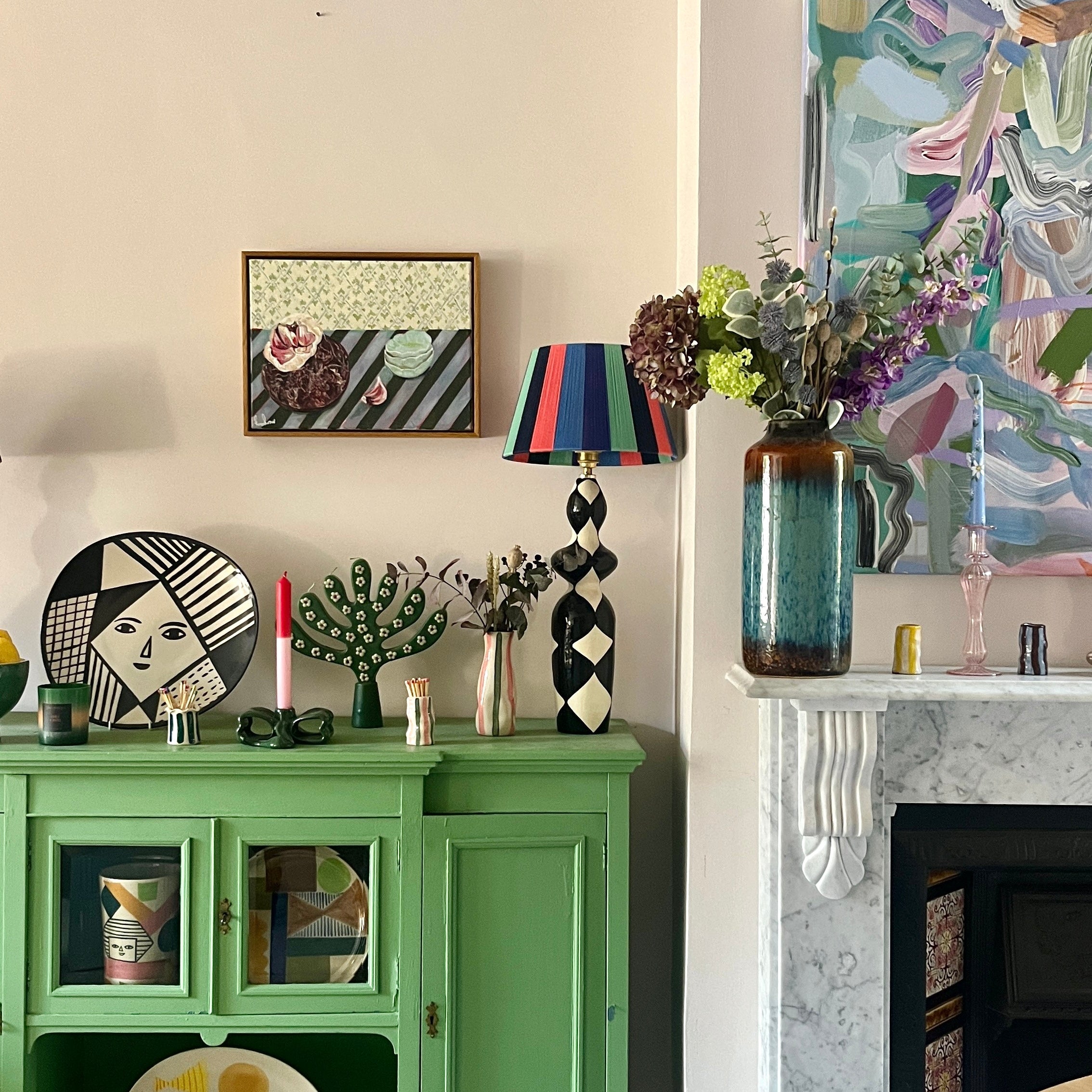 Original oil painting Garlic Against the Grain by Emma Gurner, showing garlic cloves on a plate against layered striped blue-green and floral tablecloths, framed in an oak tray frame