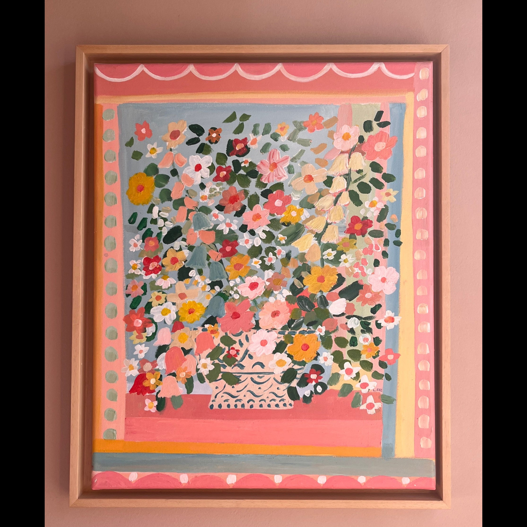Framed floral artwork on a pink wall