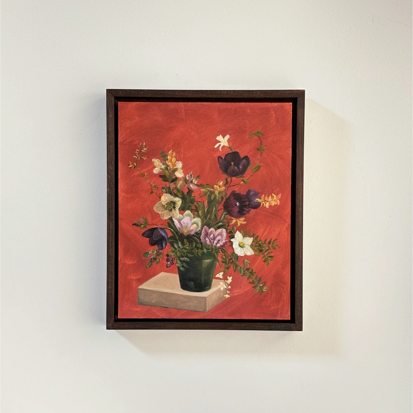 Framed artwork of a floral still life on a red background