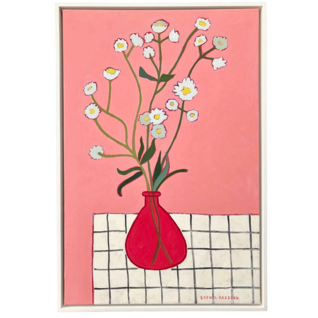 Framed artwork of a red vase with flowers on a pink background