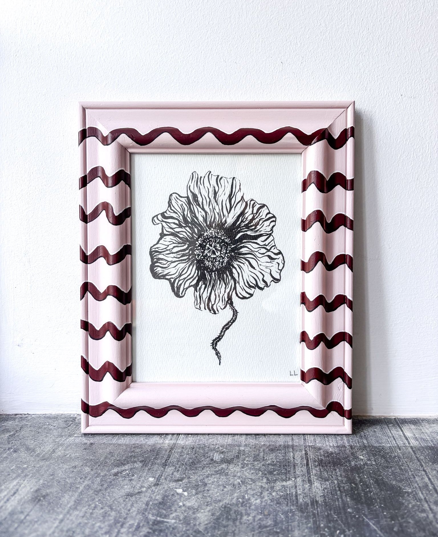 Framed black and white floral drawing with wavy pink and red frame on a light gray background
