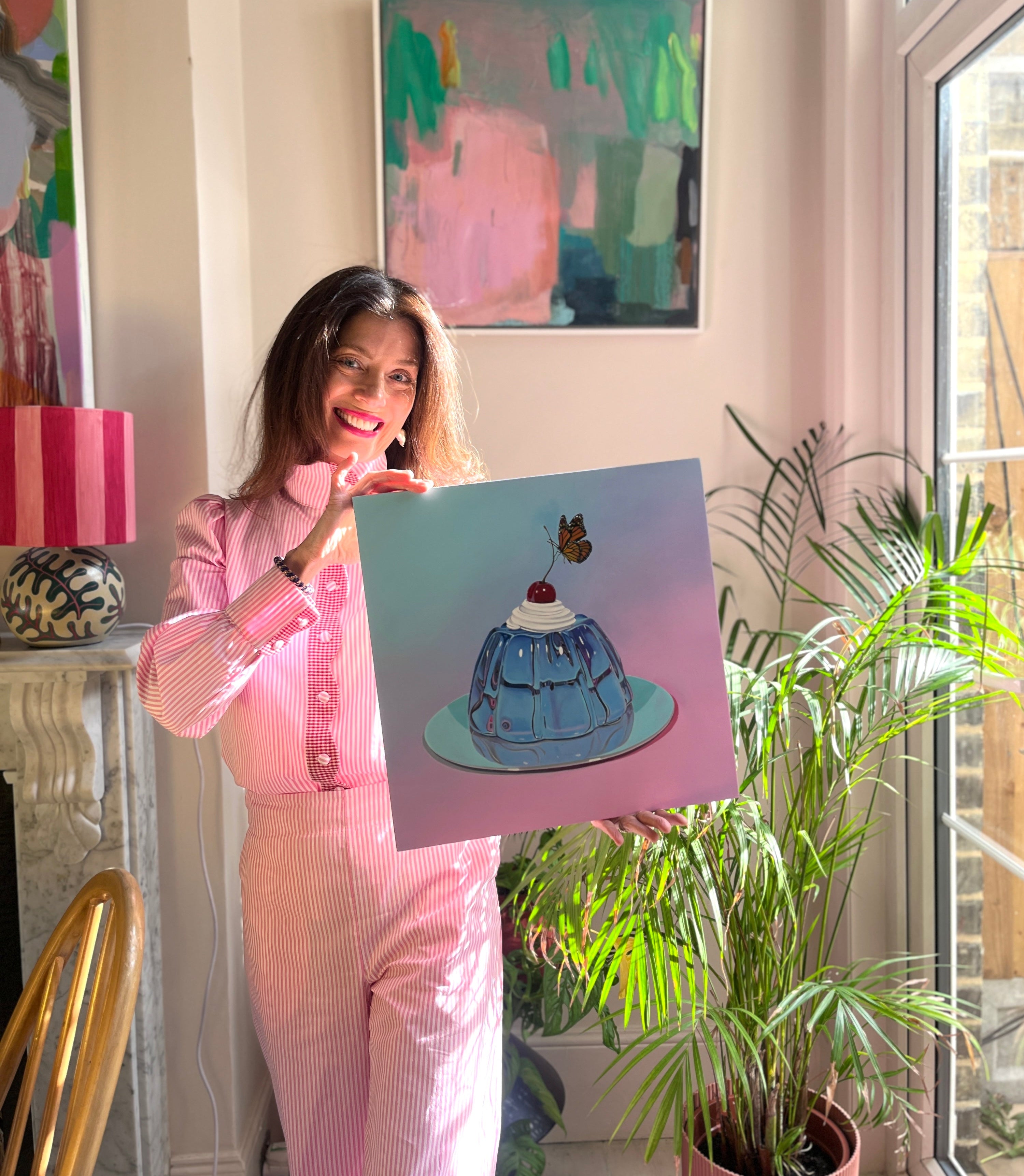 Women in pink outfit holding picture of a Jelly