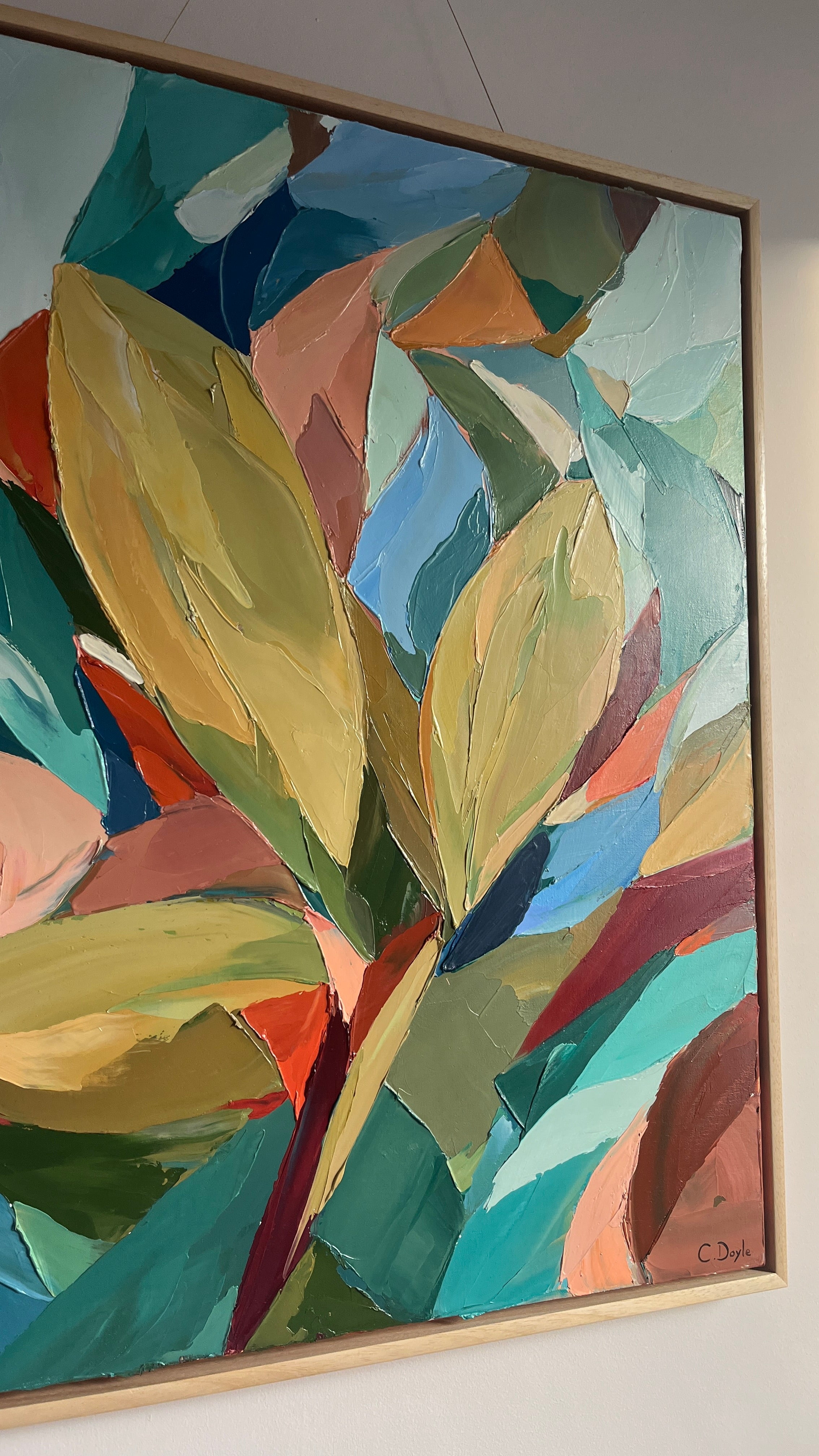 Abstract painting with colorful leaves on a white wall