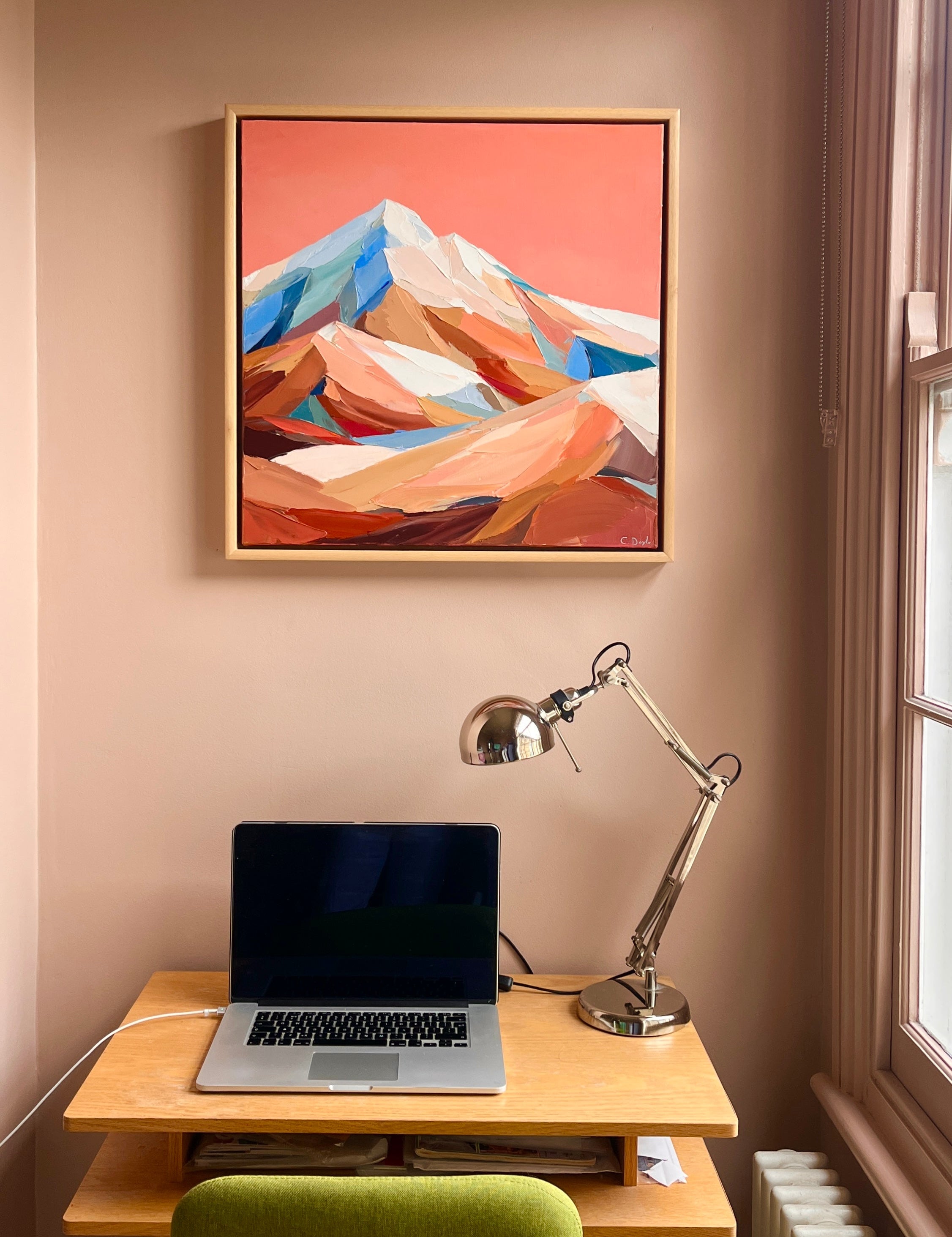 Picture of a mountain with pink sky sat above a desk 