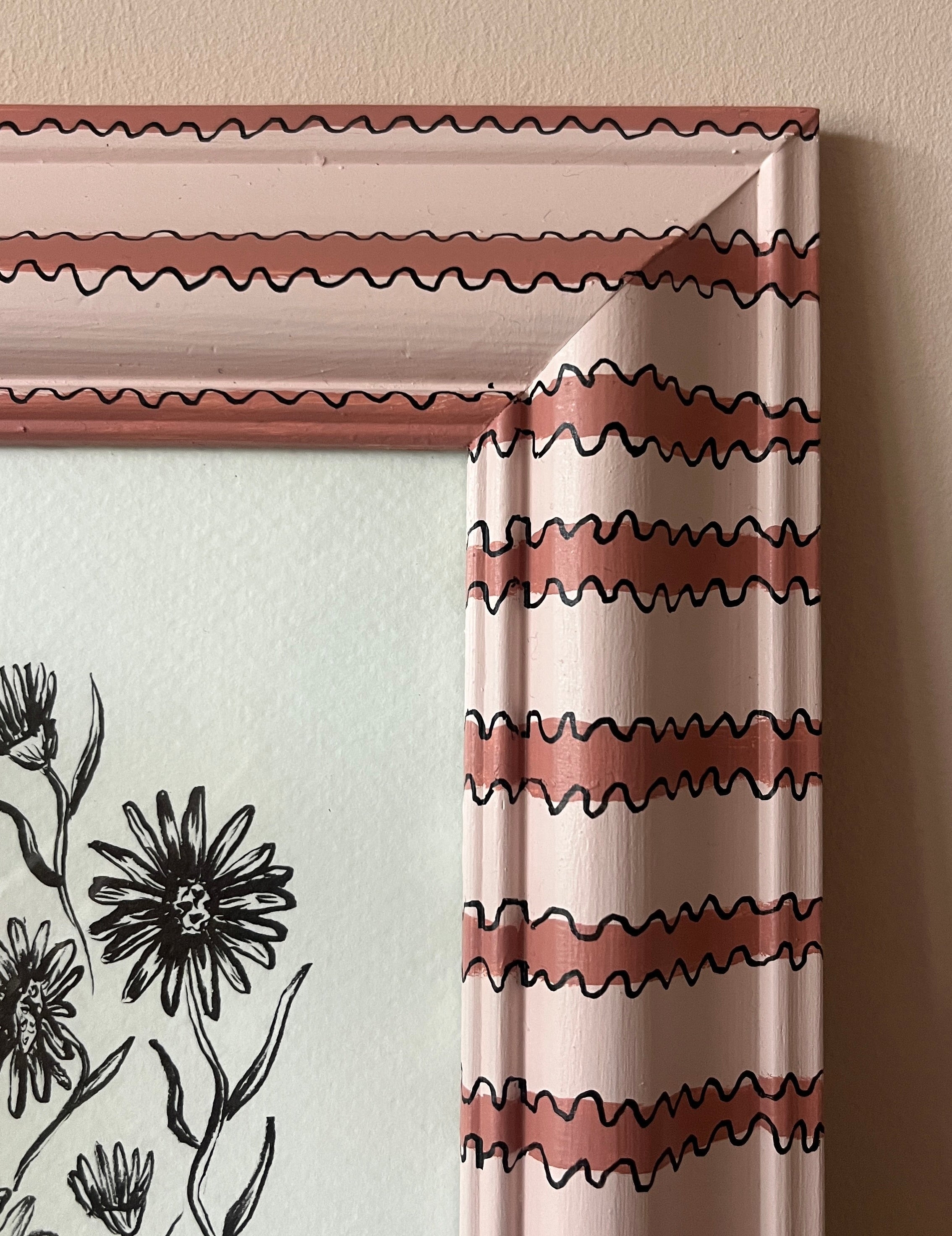Curtain with wavy pattern in a decorative frame on a wall.