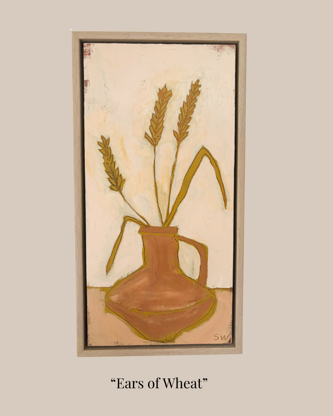 A framed still life painting titled "Ears of Wheat" showing three ears of wheat in a brown pitcher vase against a warm cream background, centered on a light beige backdrop with the title text below.