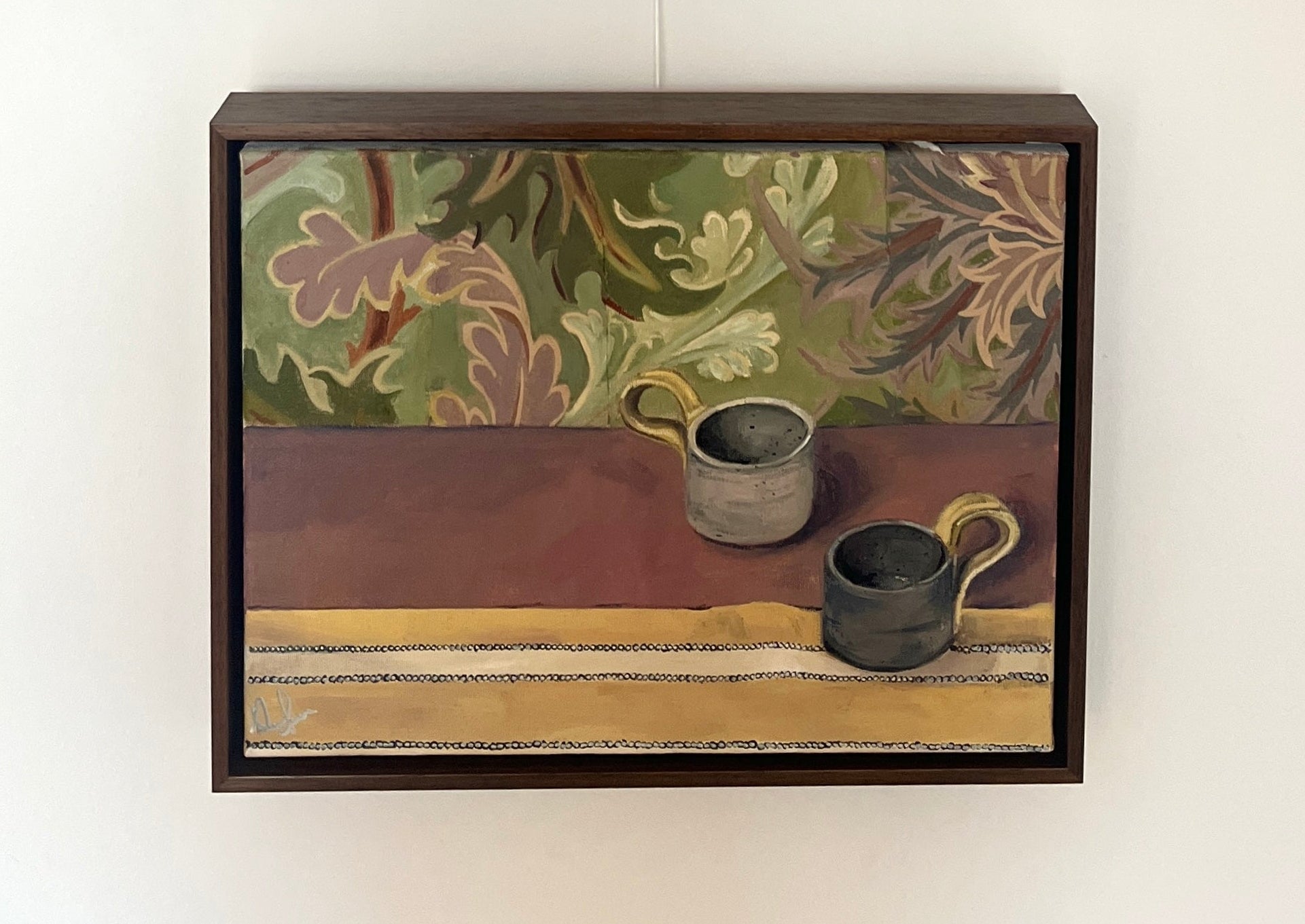 Painting of two mugs sat on table with floral wallpaper hanging on a wall. 