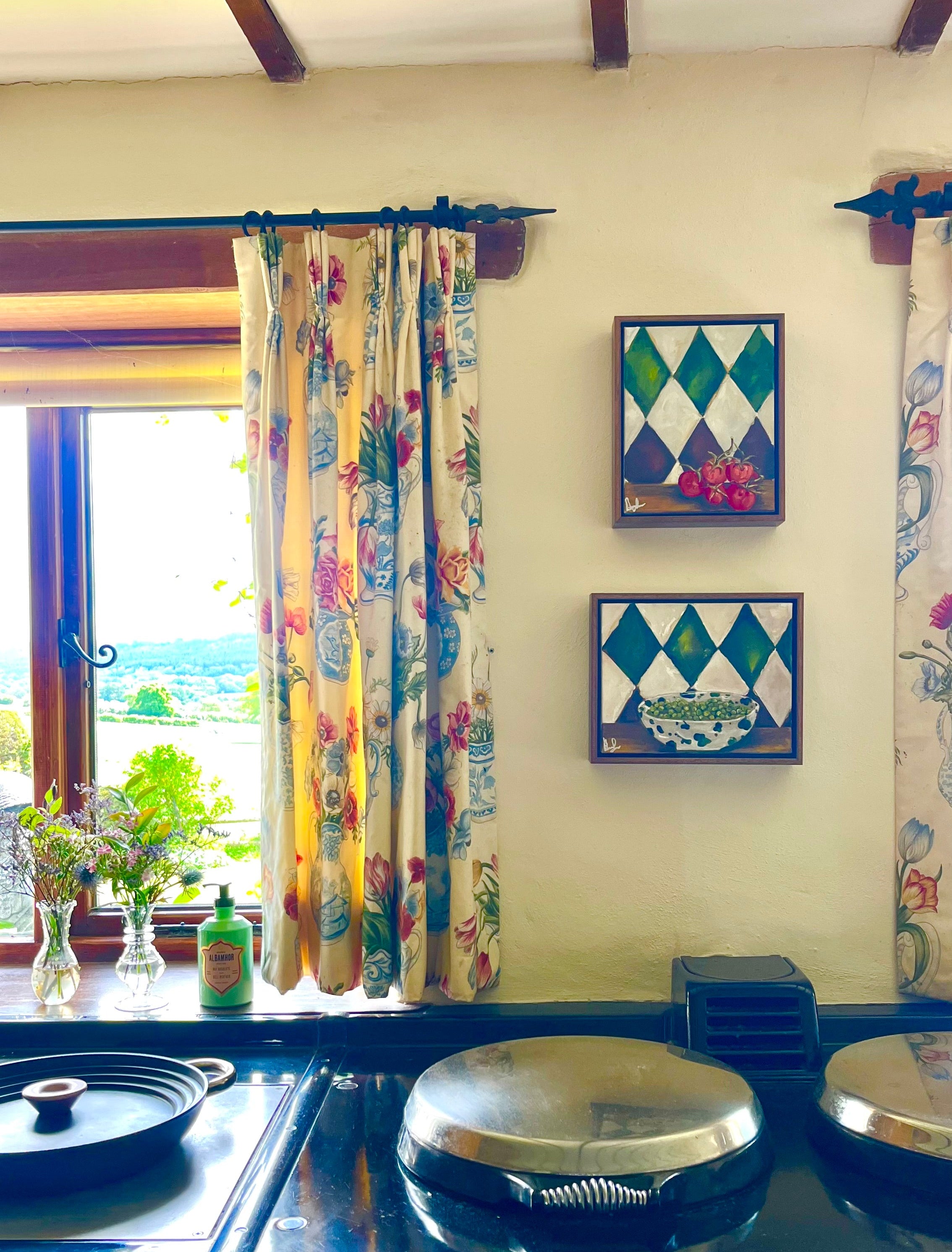 Blue stove with floral curtains and decorative tiles on a wall