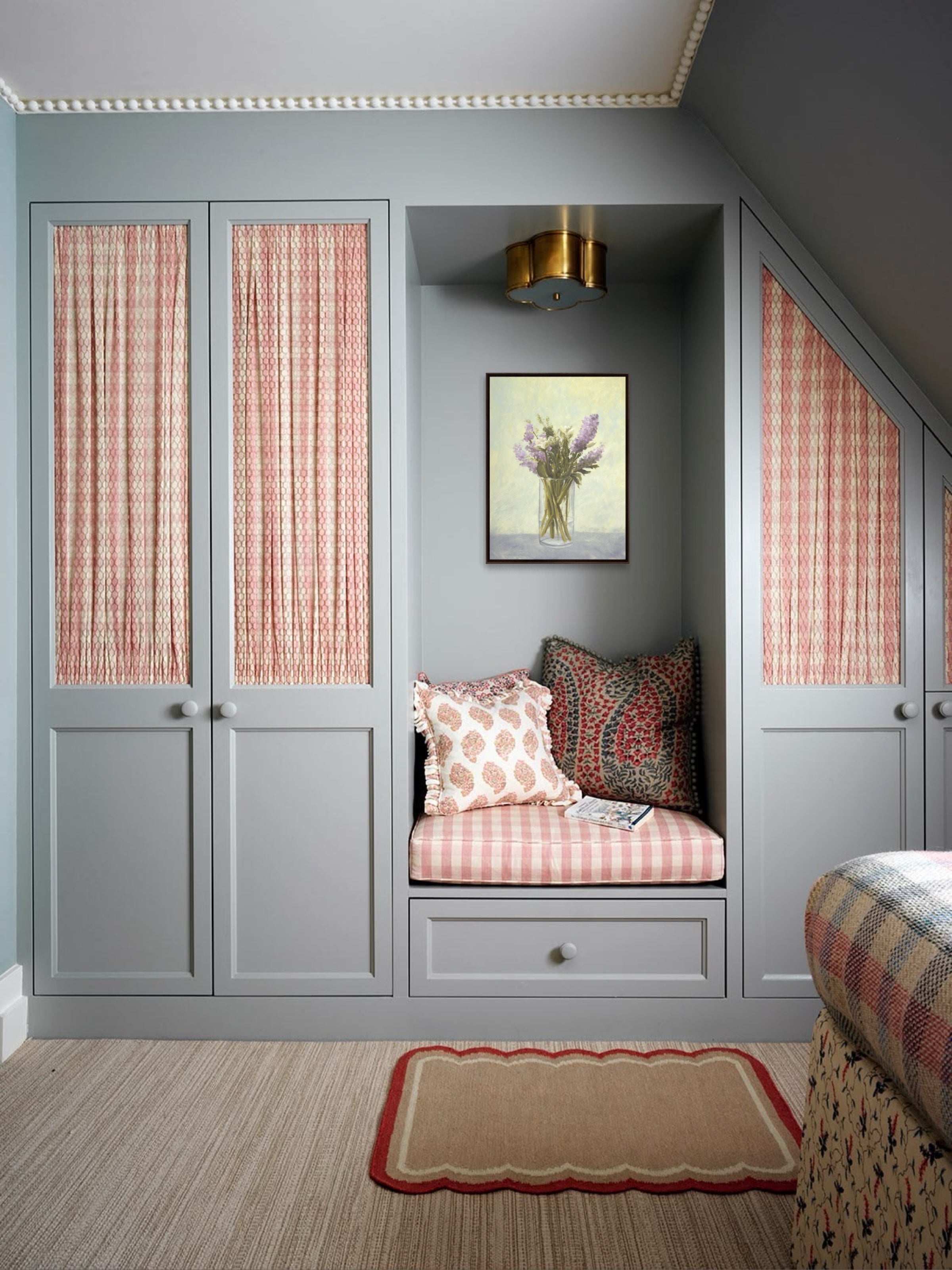 Room interior with gray walls, patterned window coverings, and a built-in bench with cushions.