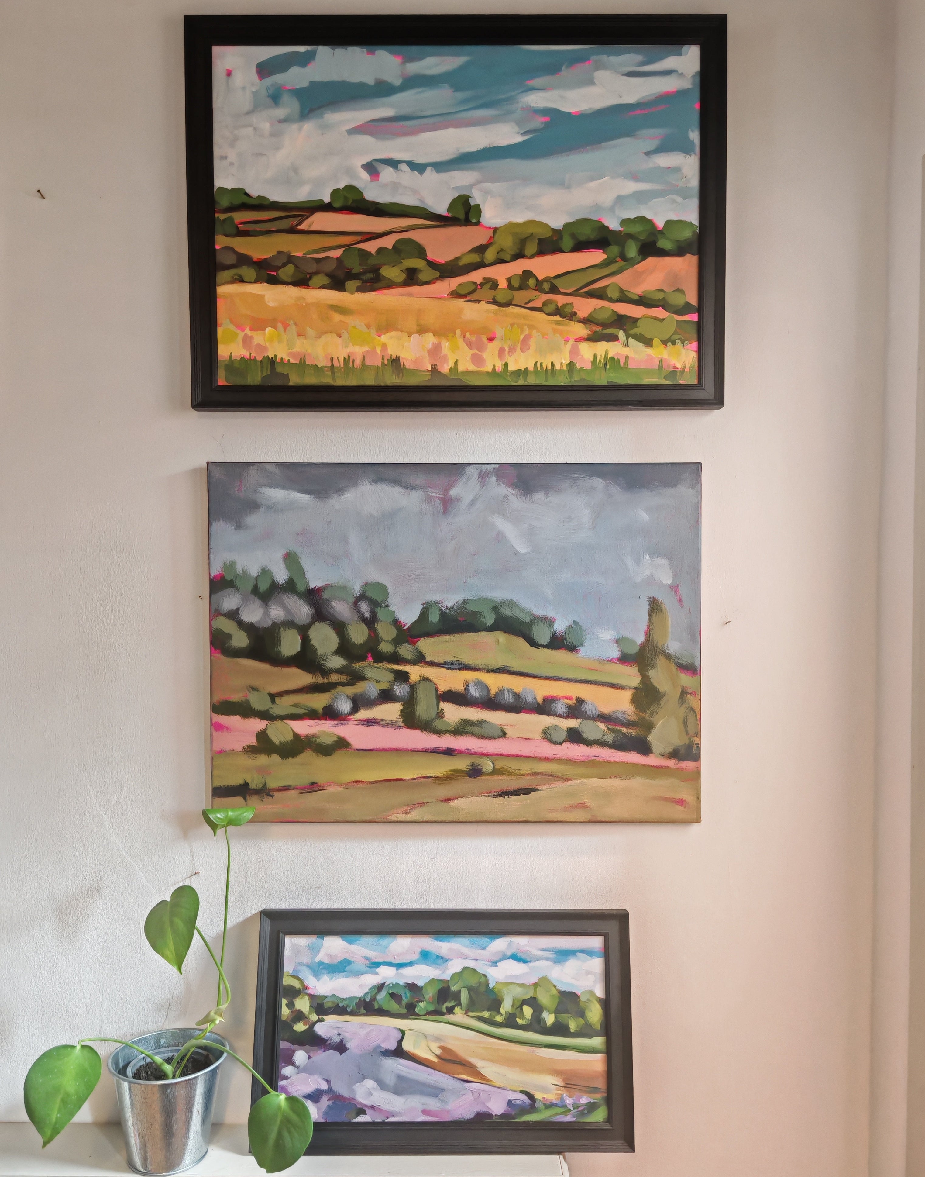 Three landscape pictures on a wall. 