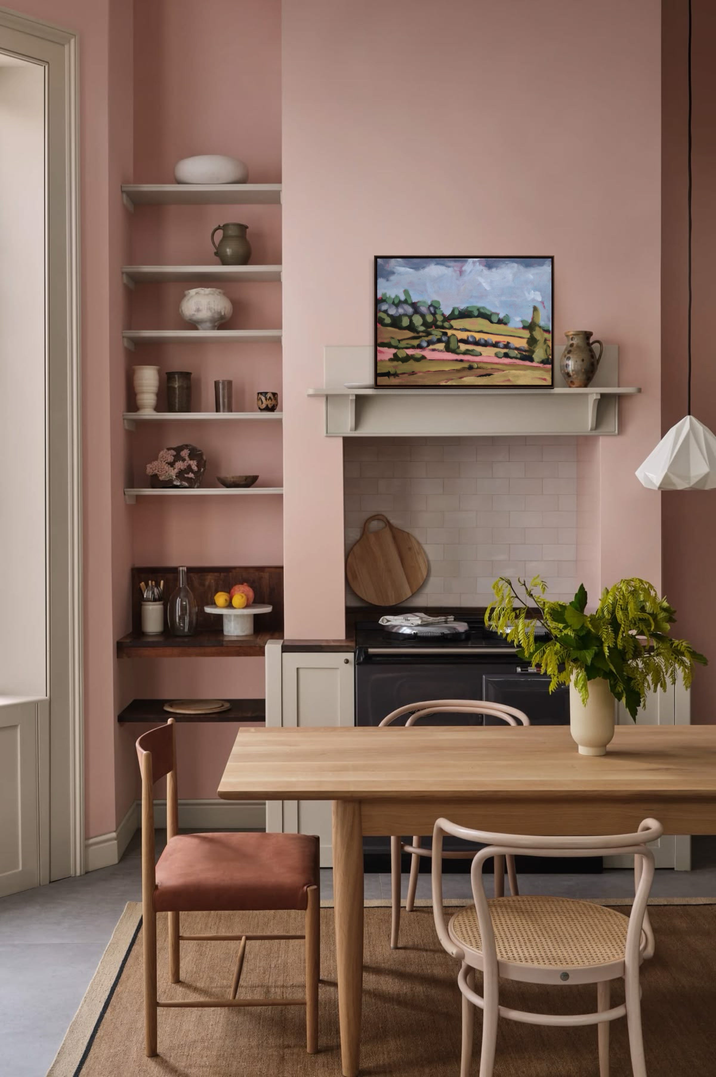 Dining area with pink walls, wooden table, and chairs.