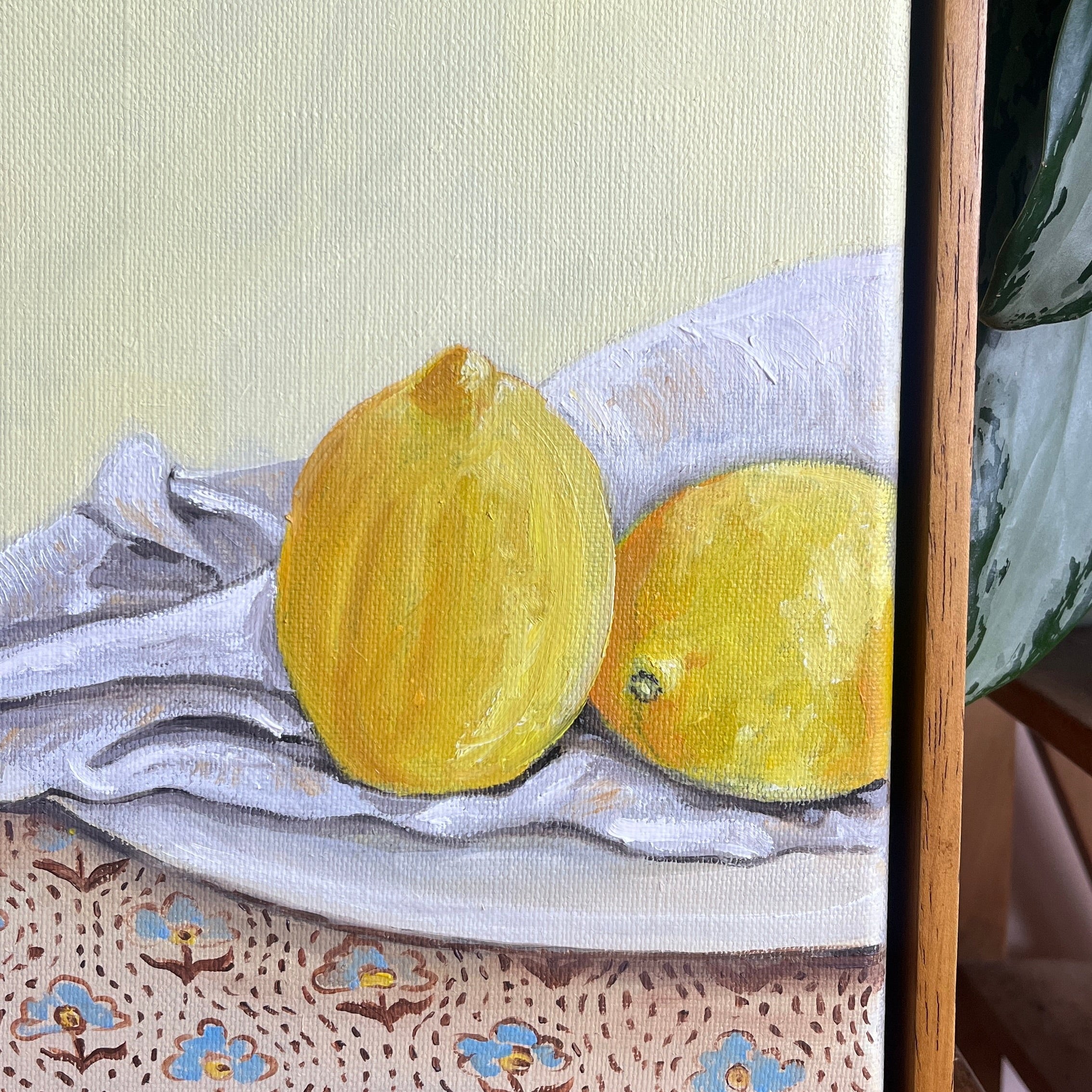 Two lemons on a textured surface with a wooden frame