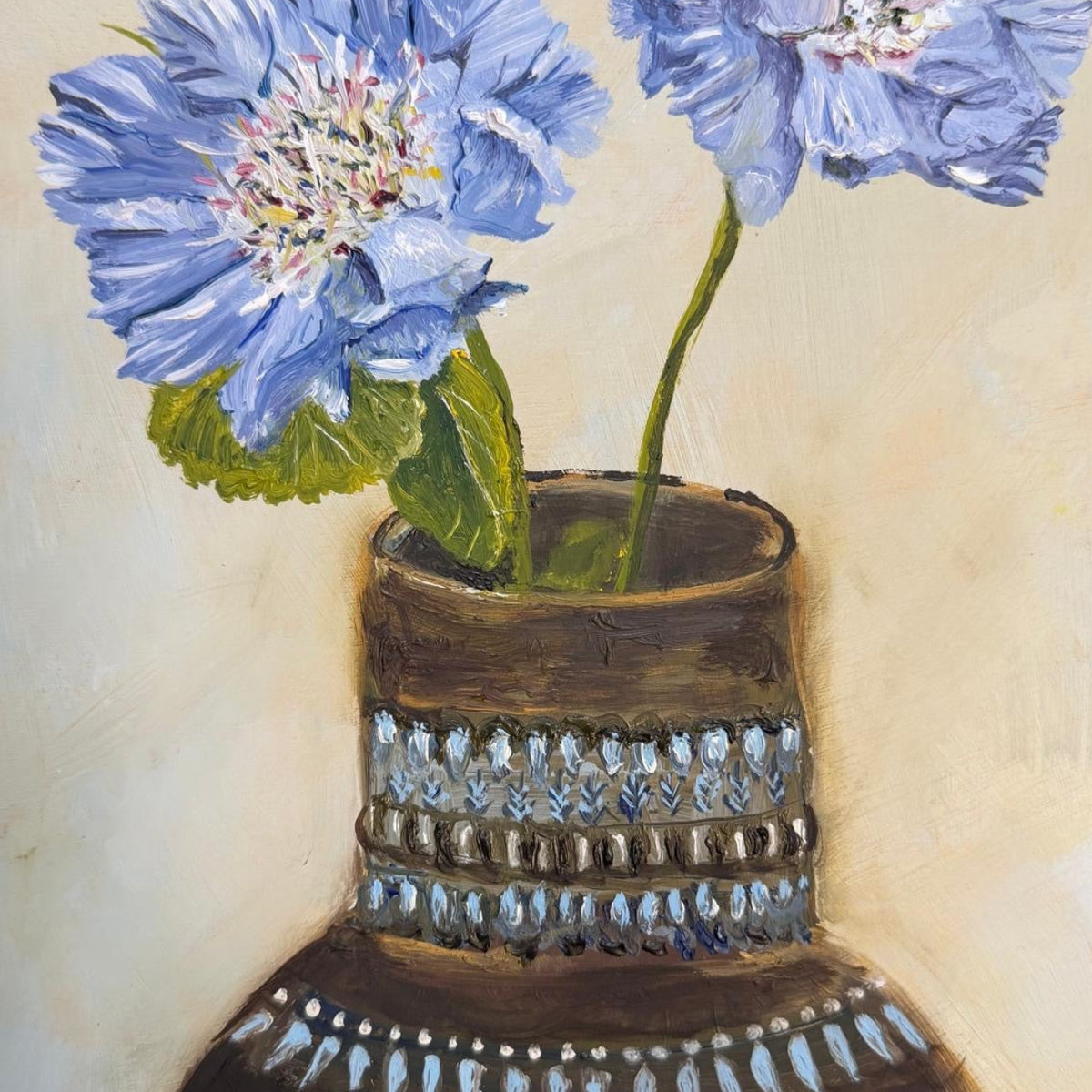 Blue flowers sat within an ornate retro vase 