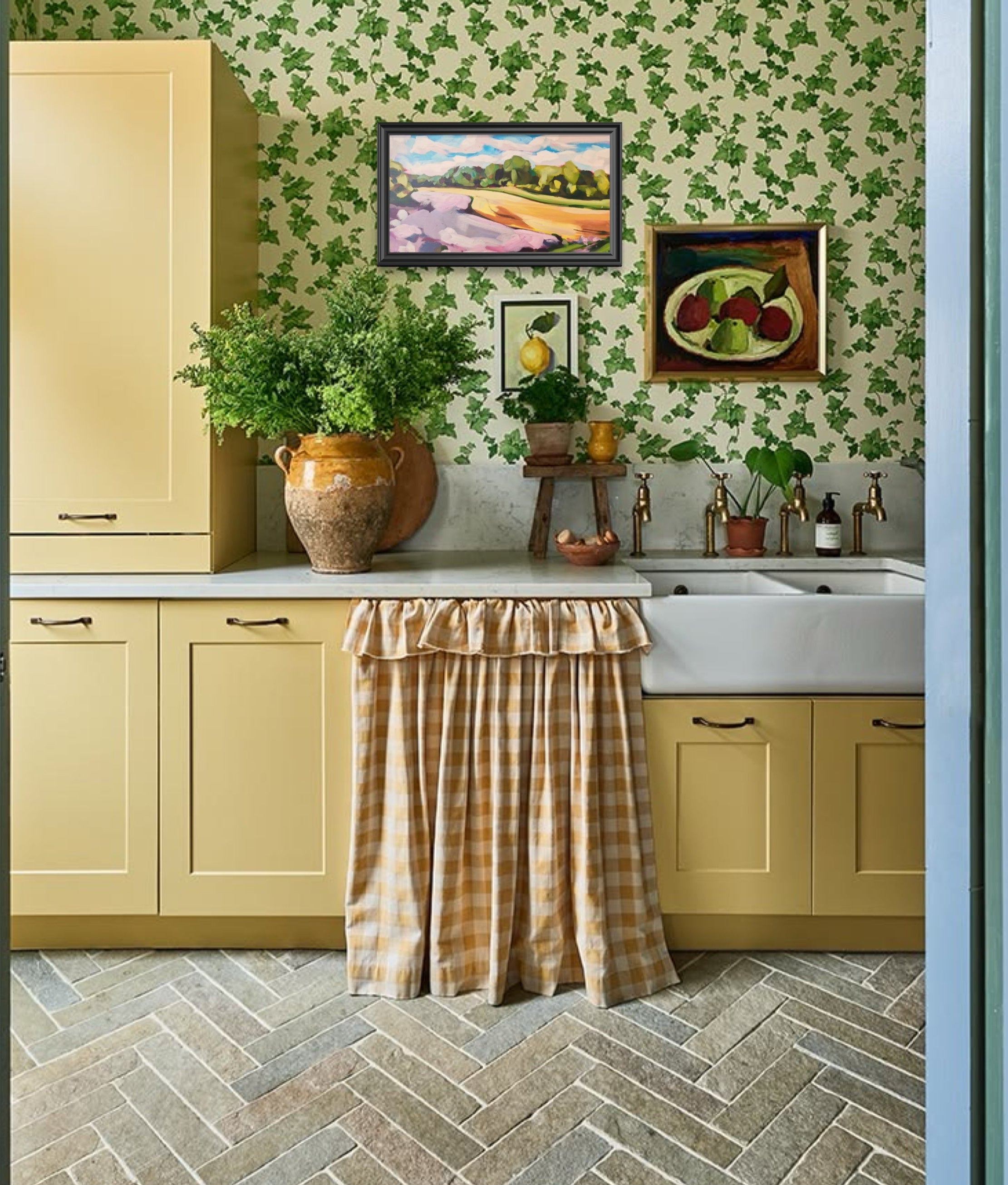 Kitchen with green leaf wallpaer with art above the kitchen sink
