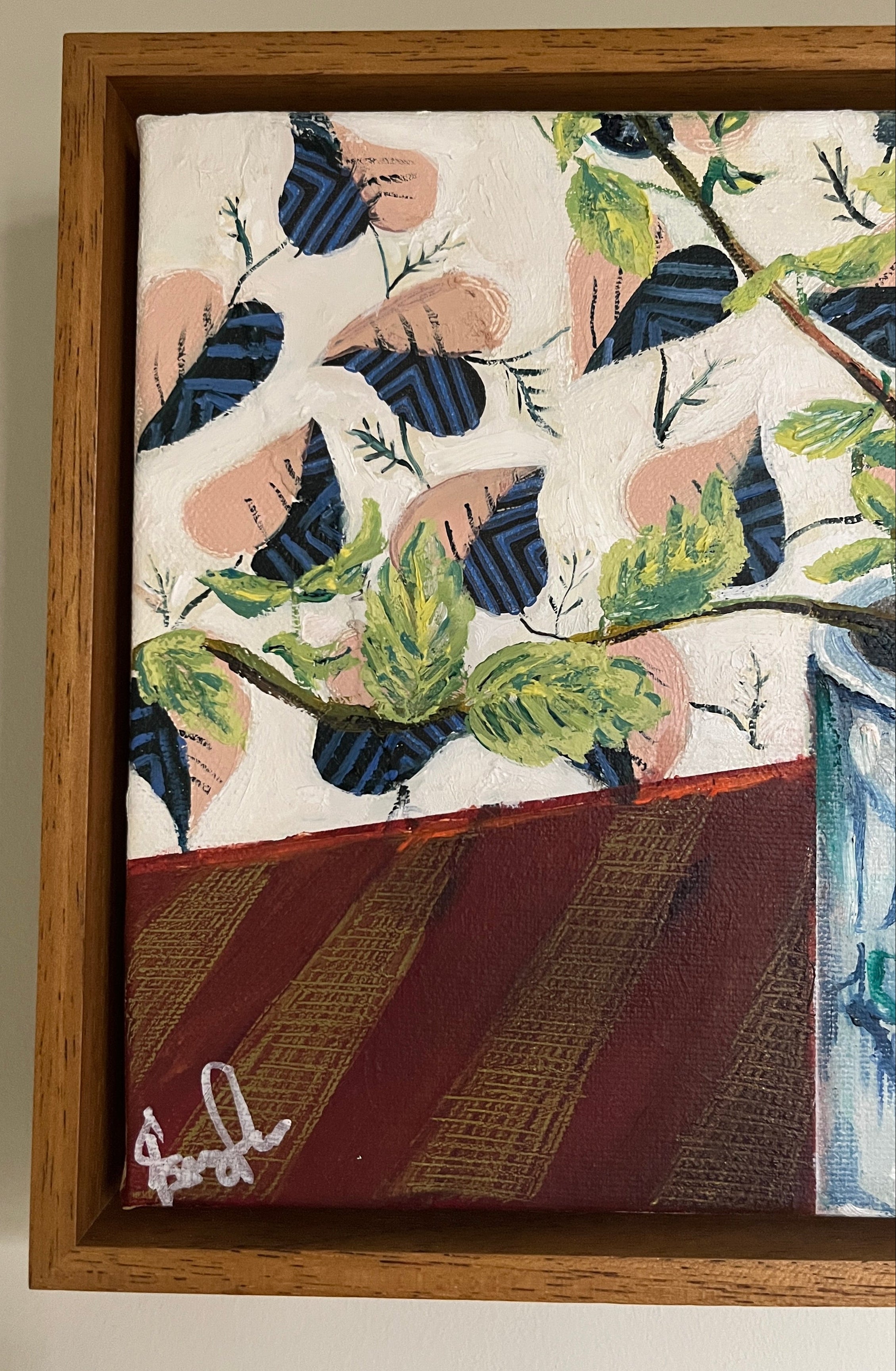 Framed artwork with leaf pattern on a beige wall