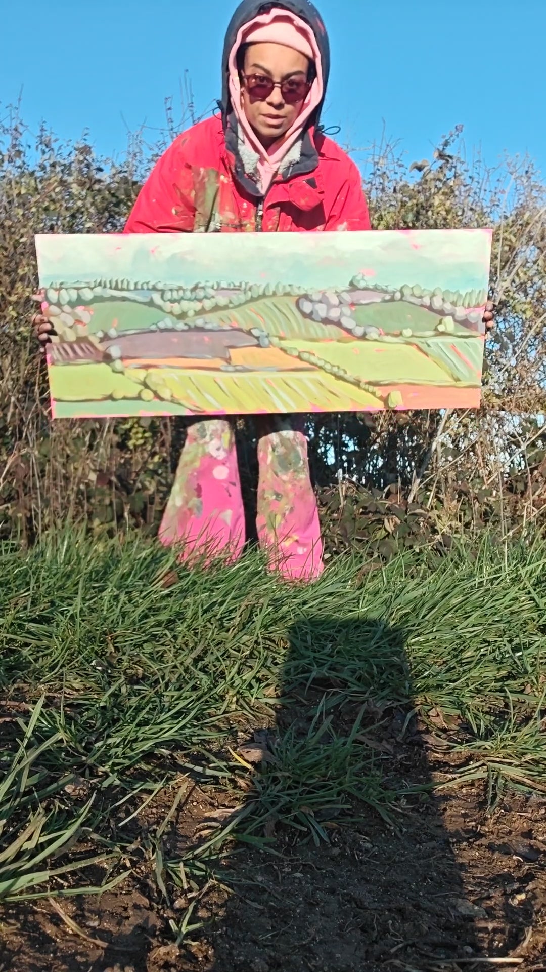 Woman showing painting  of a landscpae in the countryside 